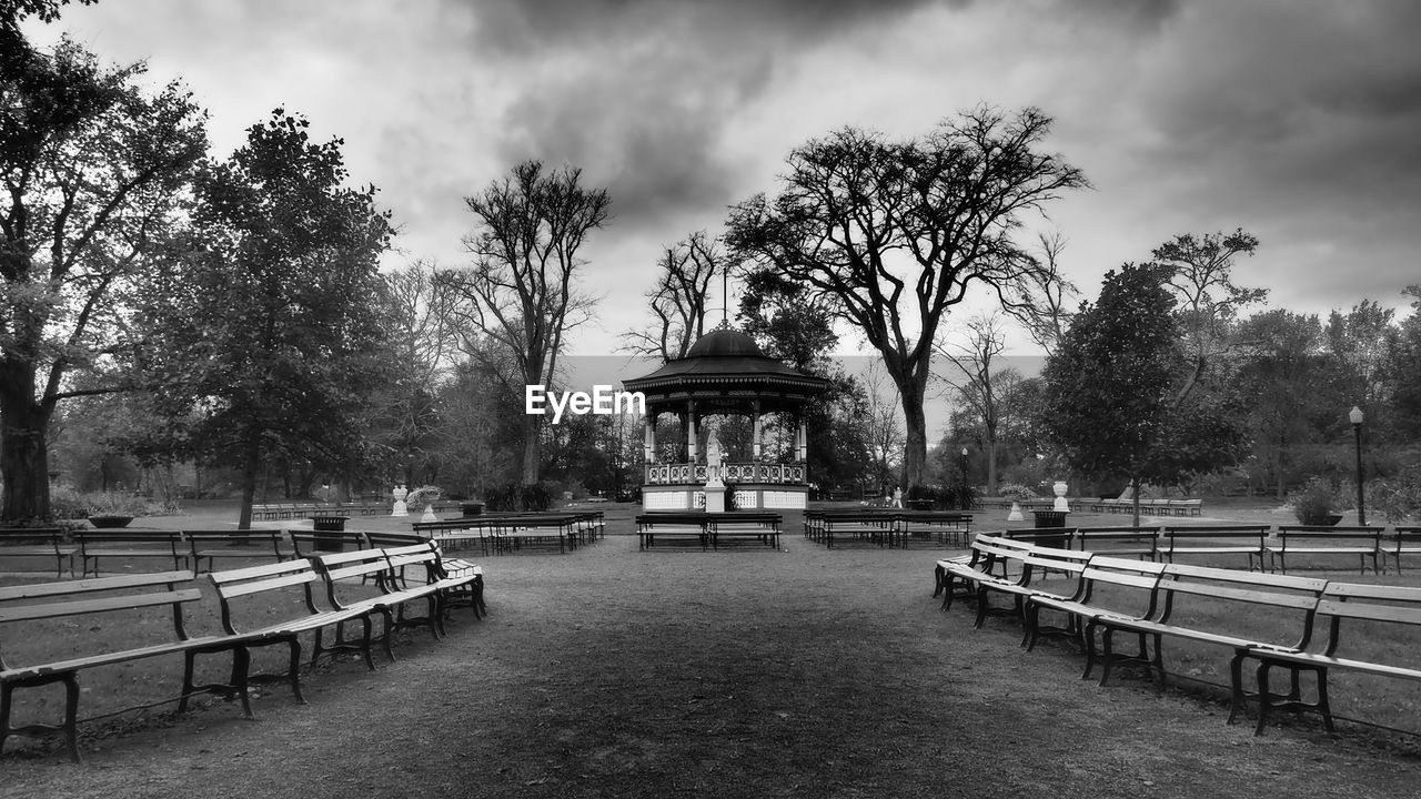 tree, plant, architecture, sky, cloud, nature, park, bench, park - man made space, built structure, seat, monochrome, water, black and white, travel destinations, monochrome photography, urban area, outdoors, park bench, no people, building exterior, day, city, travel, railing, cityscape