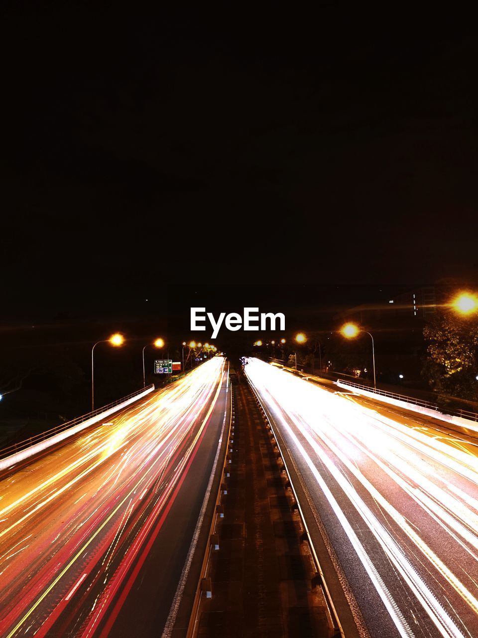 HIGH ANGLE VIEW OF LIGHT TRAILS ON ROAD IN CITY