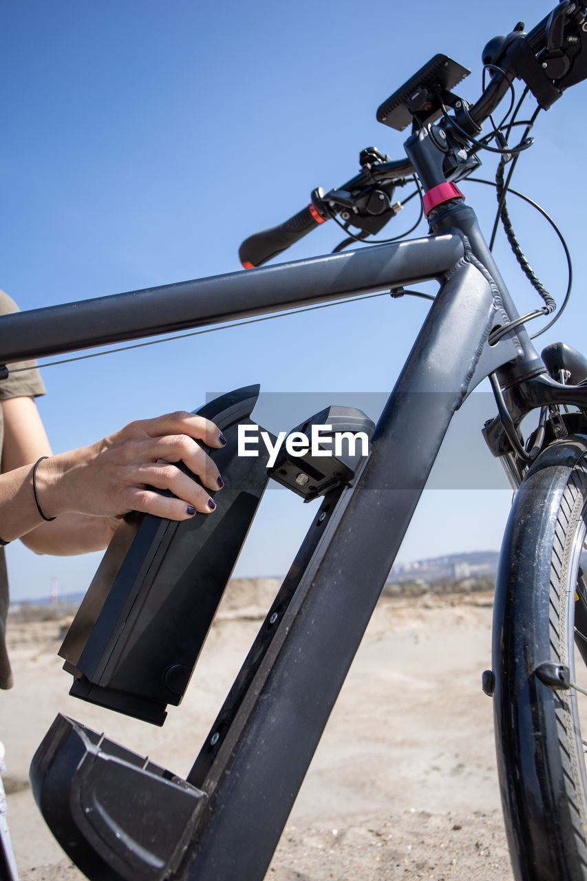 PERSON HOLDING BICYCLE ON LAND