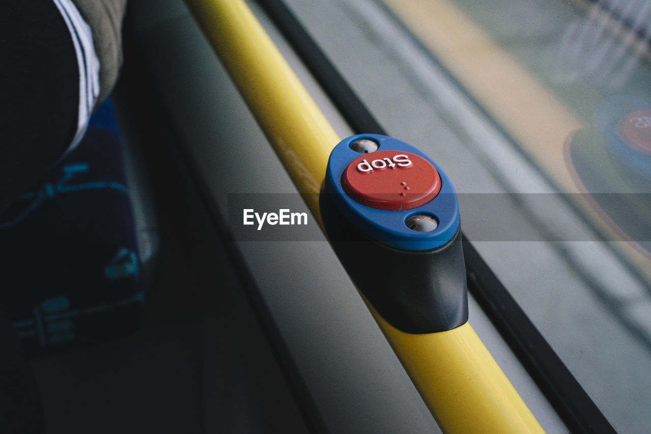 Close-up of stop button in bus by window