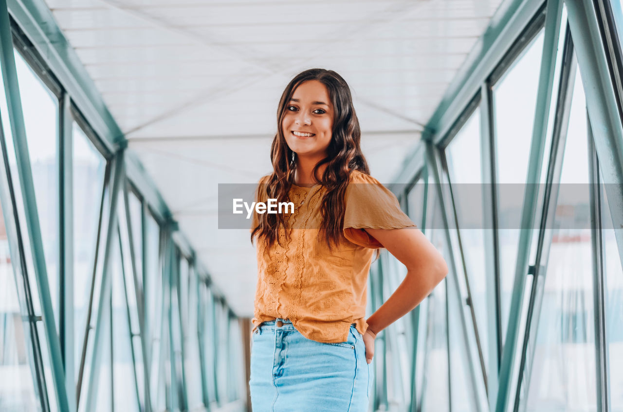 Portrait of woman standing on footbridge