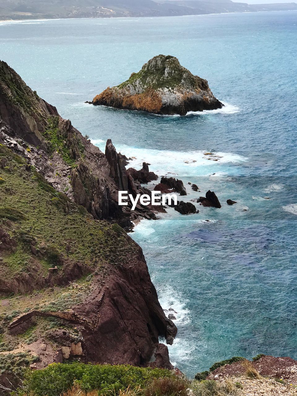 Rock formation by sea against sky