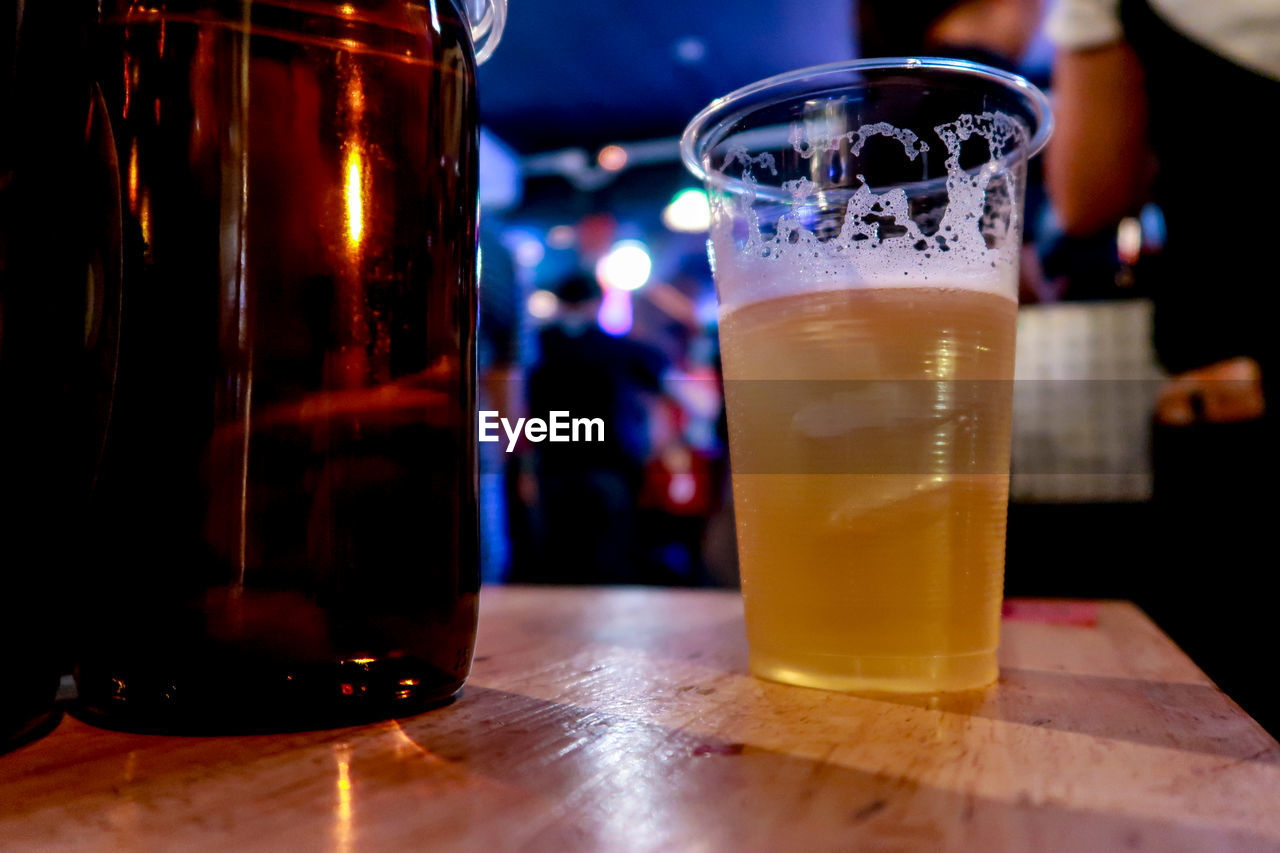 CLOSE-UP OF BEER IN GLASS ON TABLE