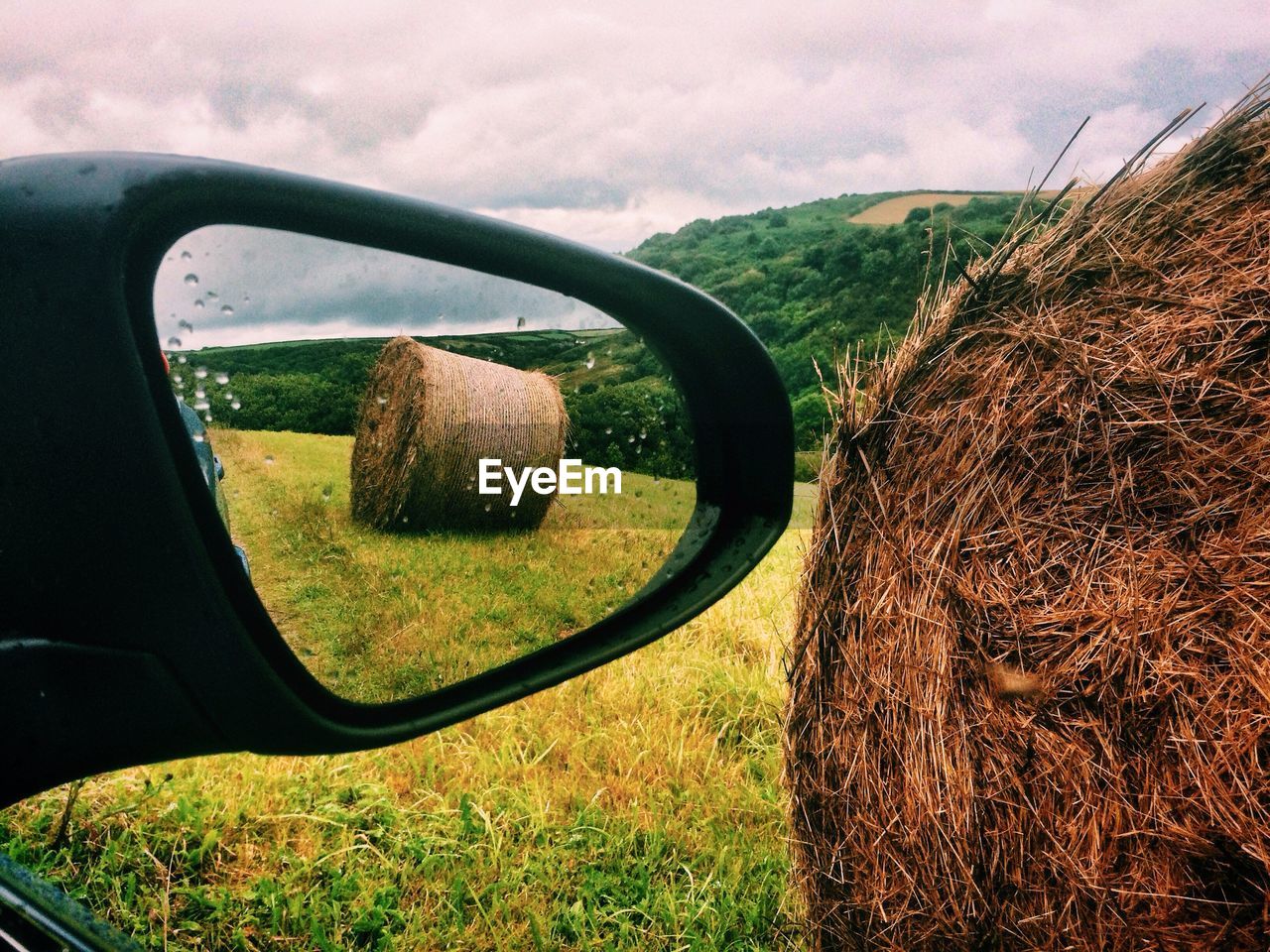 Reflection of hay bale in side-view mirror