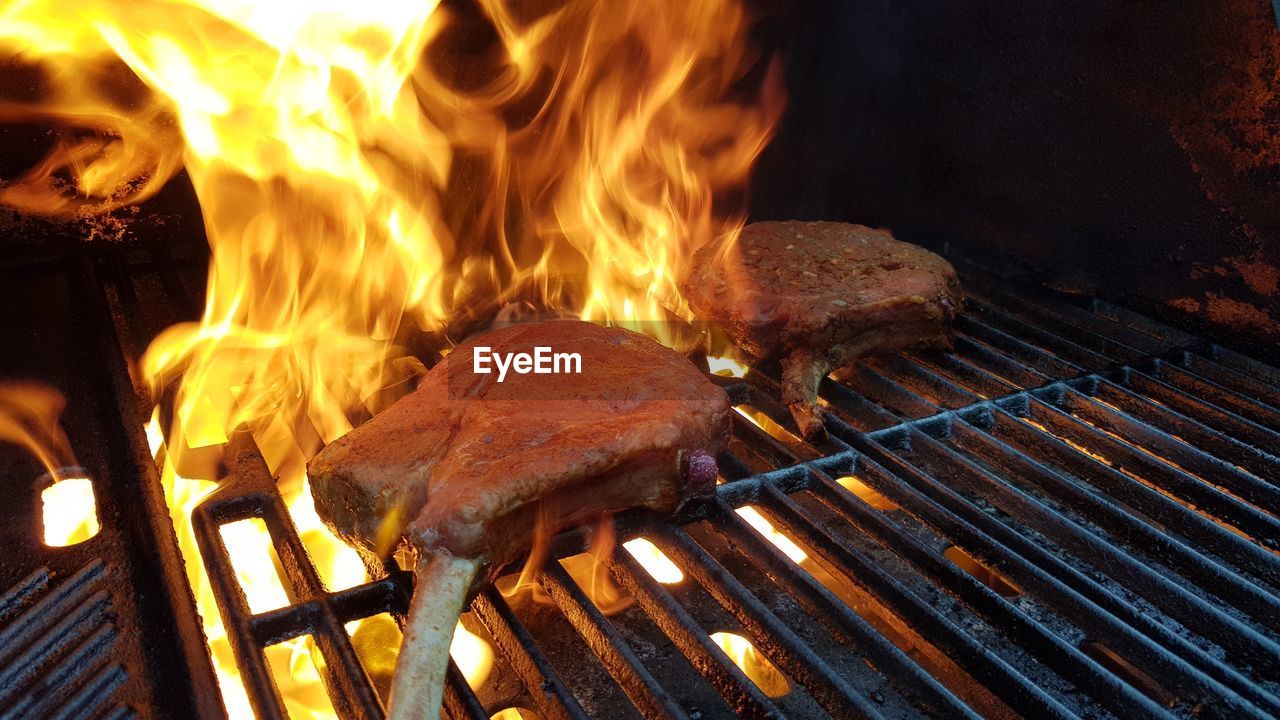 Close-up of fire on barbecue grill wirh tomahawk steaks