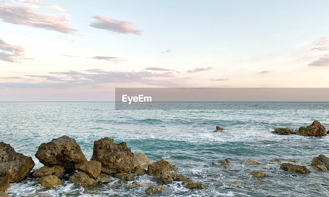 ROCKS IN SEA AGAINST SKY