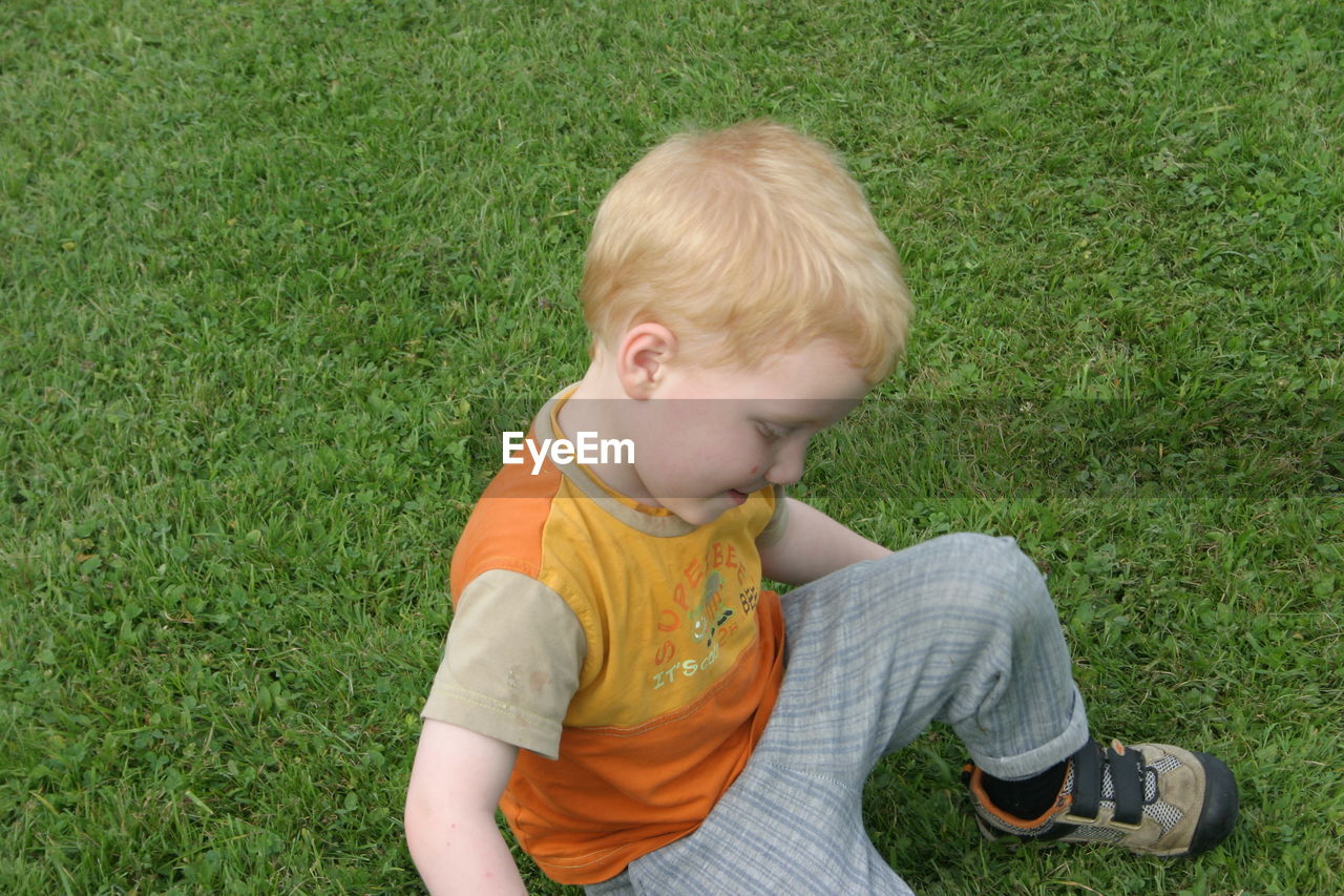 High angle view of boy playing on grassy field