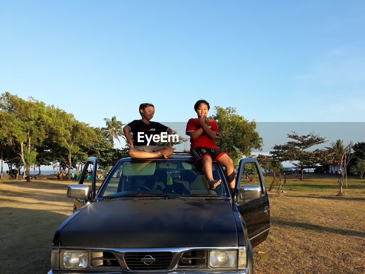 FRIENDS SITTING ON MOTORCYCLE AGAINST THE SKY