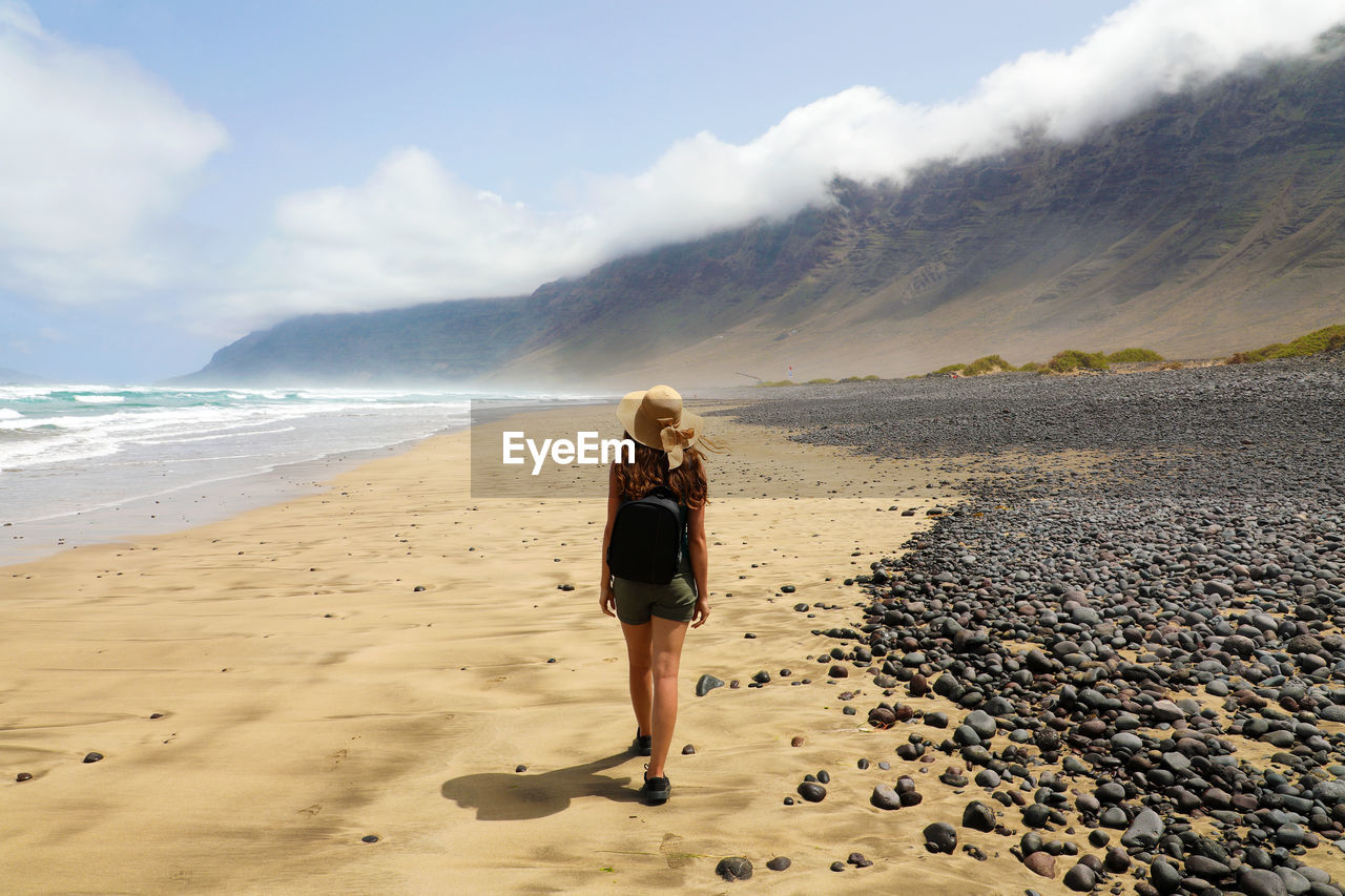 Rear view full length of woman walking at beach