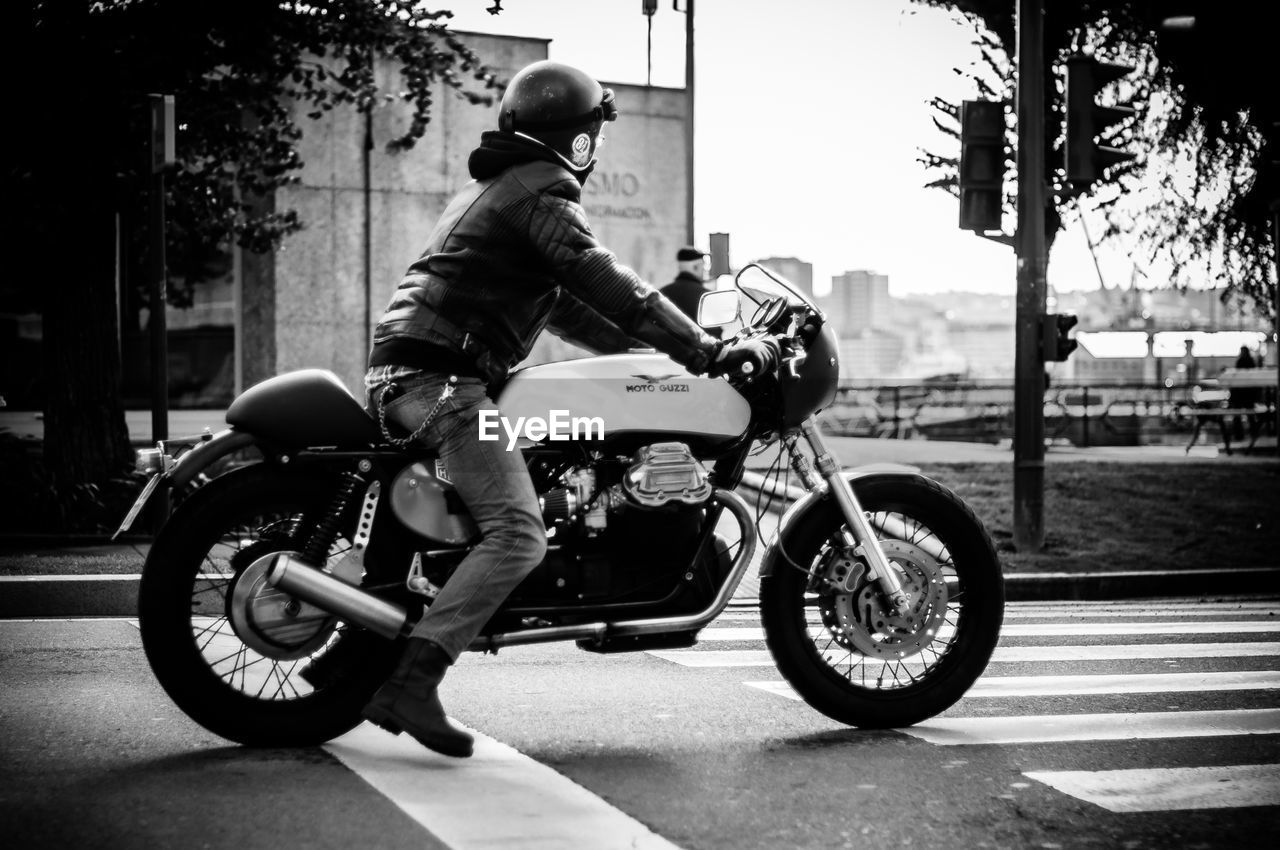 MAN RIDING BICYCLE ON ROAD IN CITY