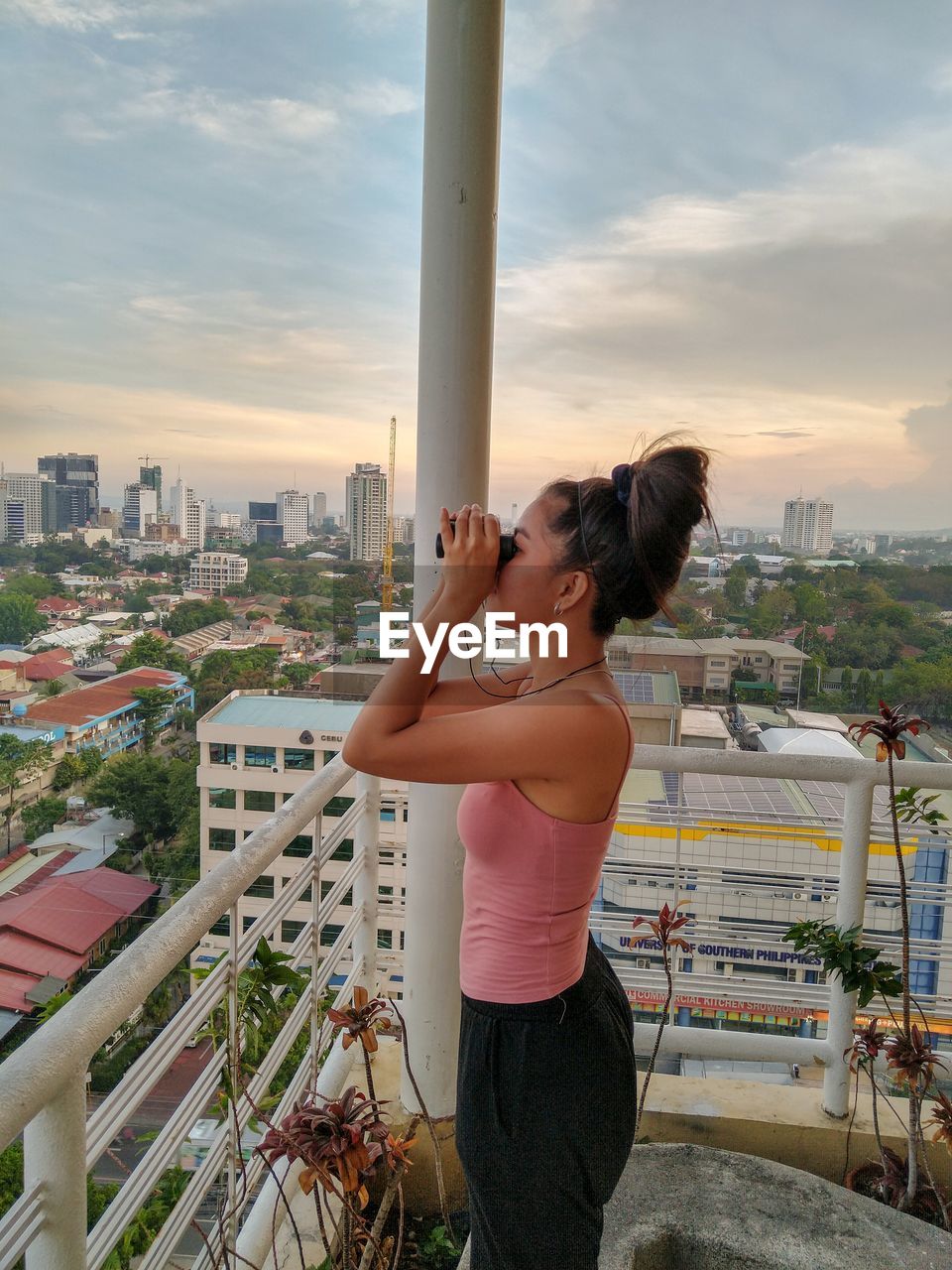 FULL LENGTH OF WOMAN STANDING AGAINST CITYSCAPE