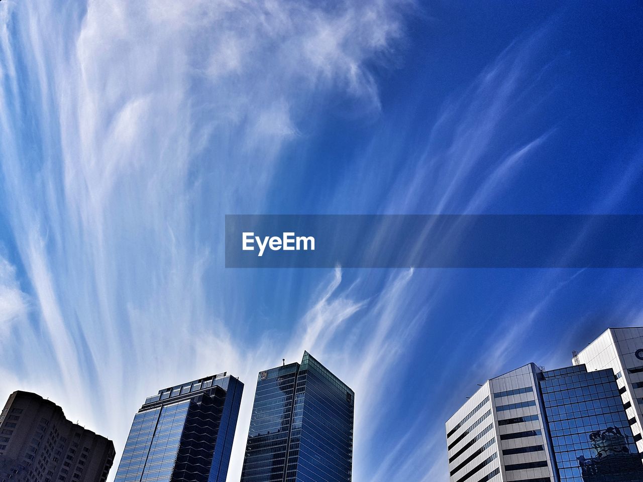 Low angle view of modern buildings against blue sky