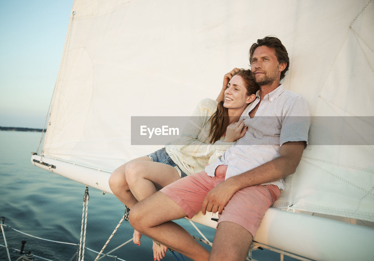 Couple relaxing while traveling in yacht