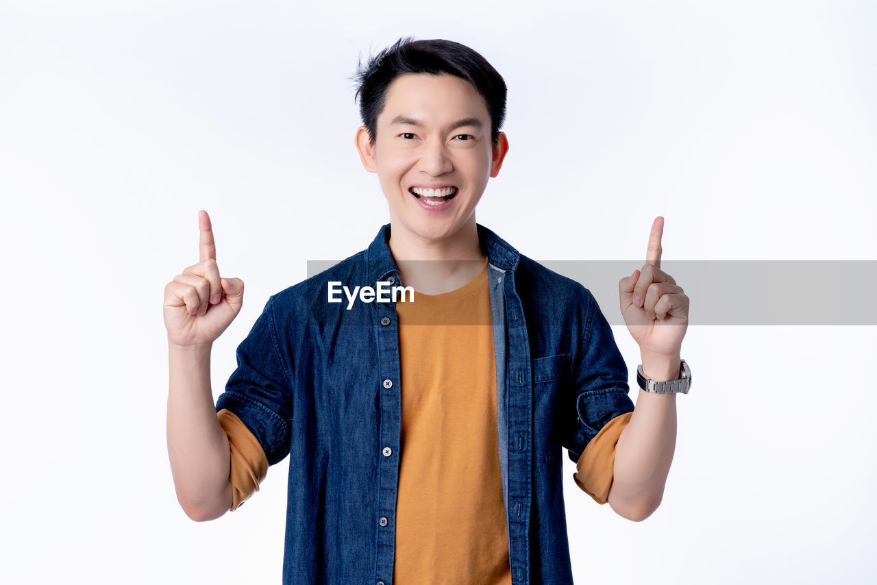 PORTRAIT OF SMILING MAN STANDING AGAINST WHITE BACKGROUND