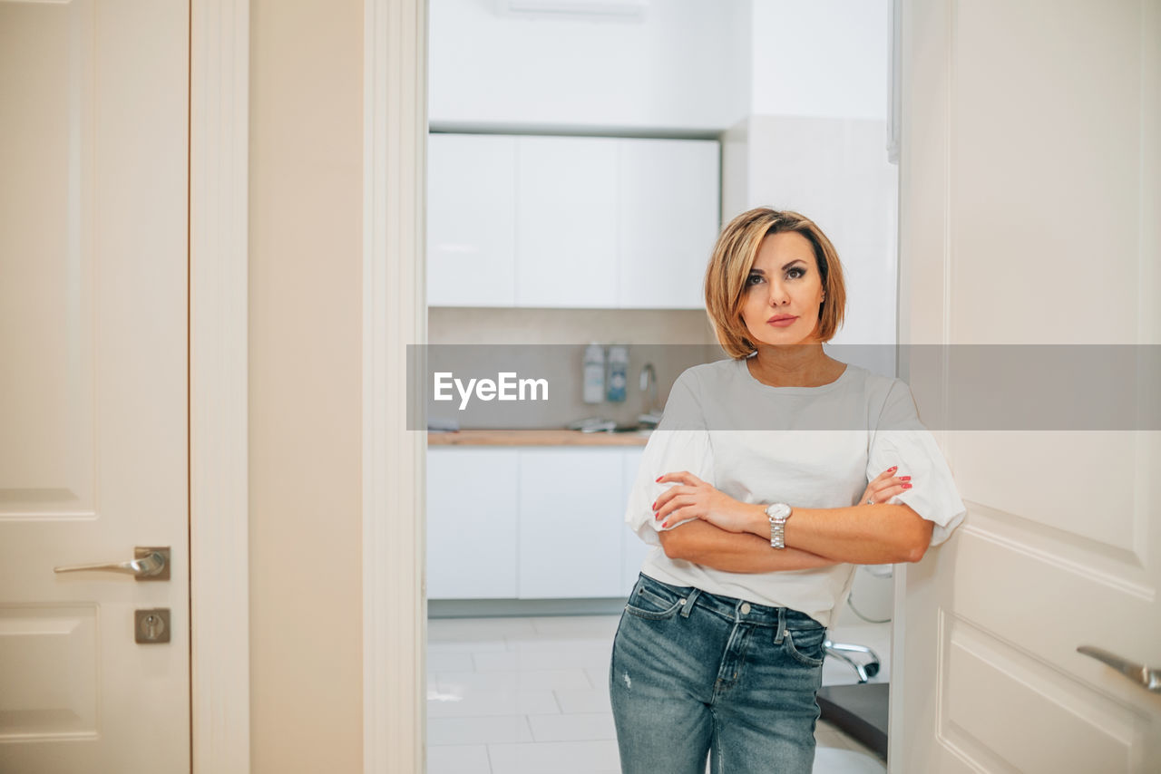 Close-up portrait of a beautiful slim woman in the doorway of a bright medical office. mock-up