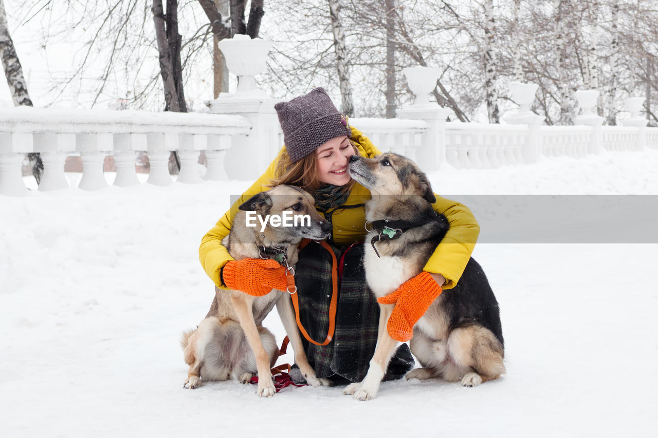 Woman with dogs on snow covered street