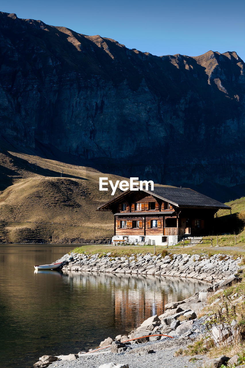 House at lakeshore near mountains