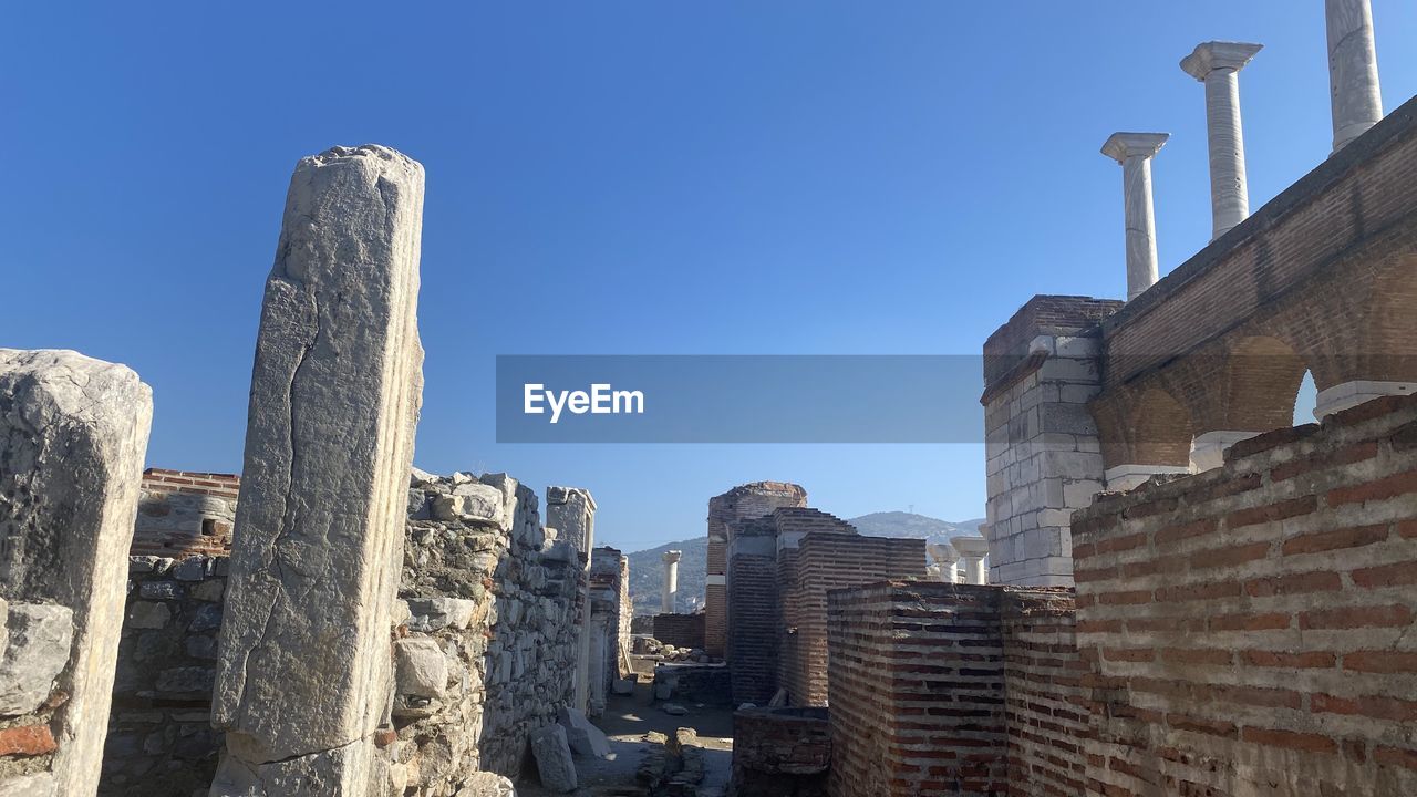 LOW ANGLE VIEW OF OLD BUILDINGS AGAINST BLUE SKY