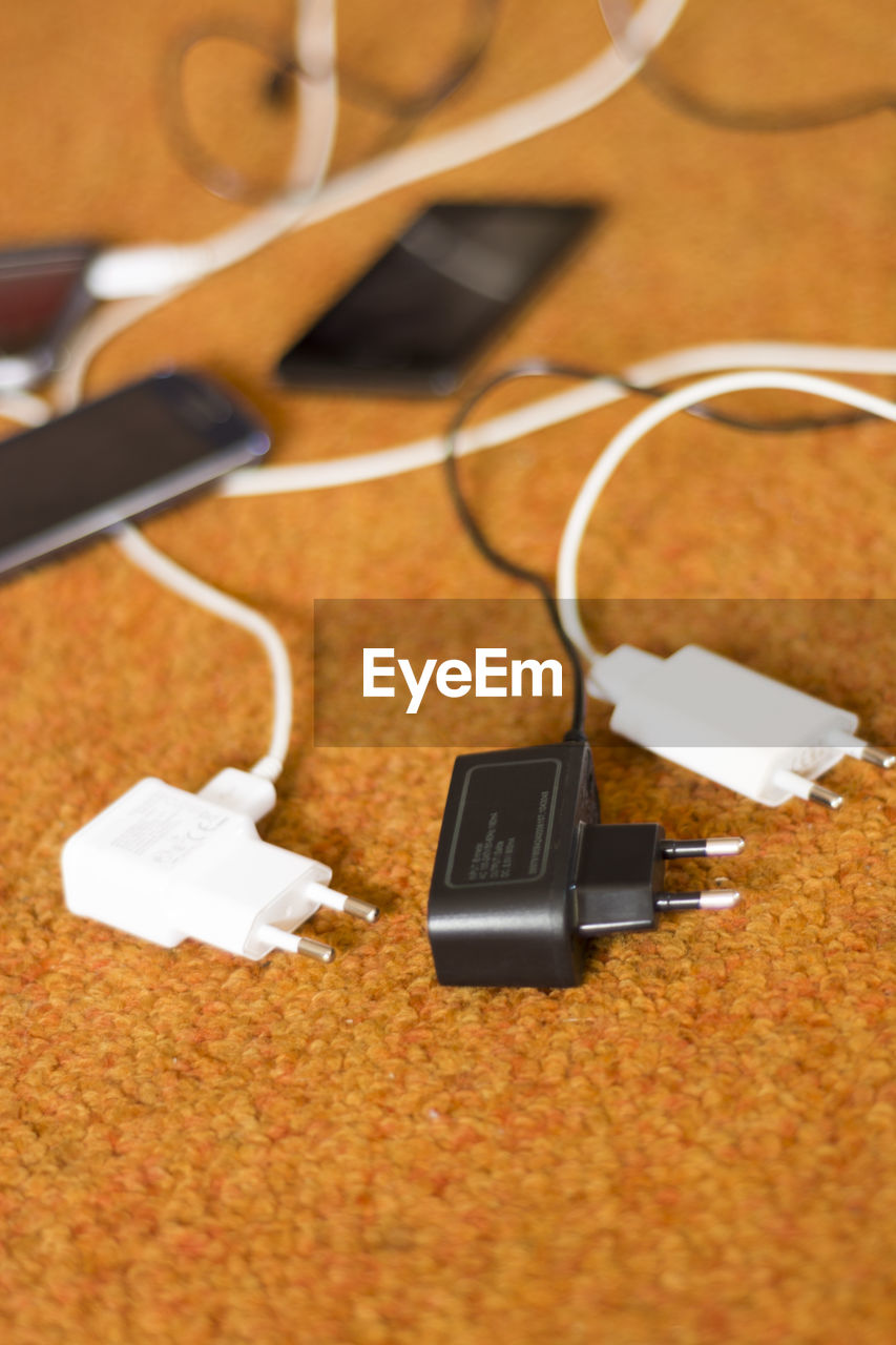 Close-up of mobile phone and chargers on table