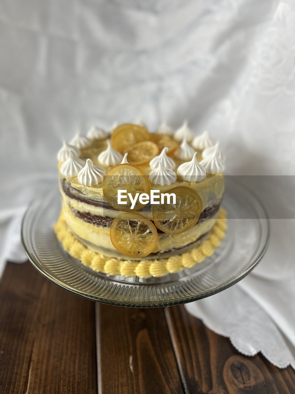 yellow, food and drink, food, icing, birthday cake, wood, cake, fashion accessory, wealth, indoors, no people, sweet food, celebration, gold, sweet, dessert, baked, plate, wedding cake, table, jewellery, wedding, silver, luxury, event, wedding ceremony supply, studio shot, focus on foreground