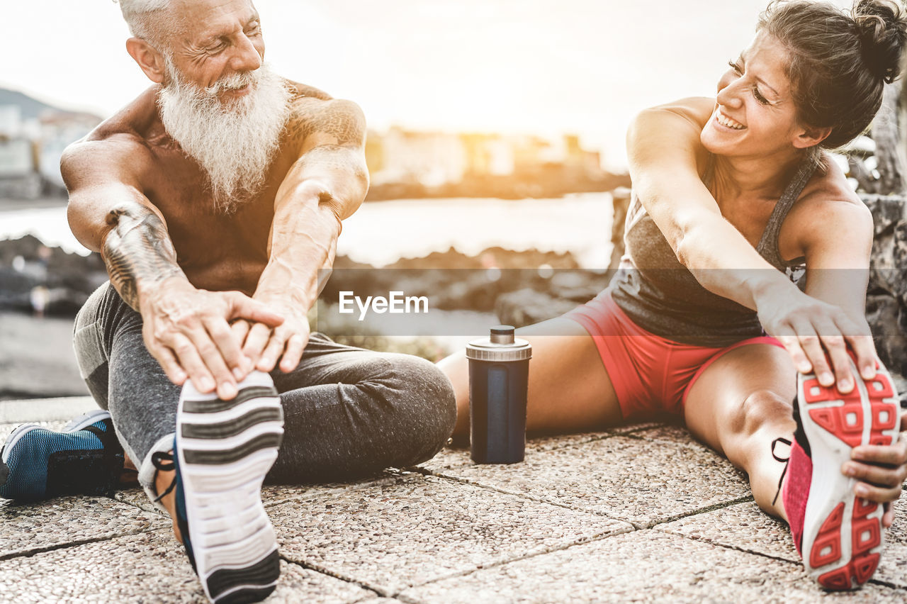 Smiling friends exercising at beach