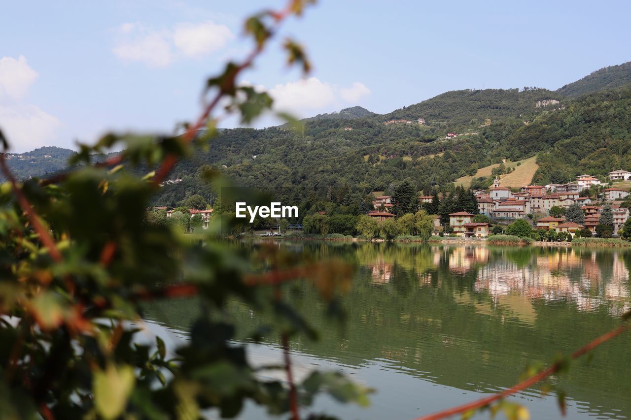 SCENIC VIEW OF LAKE AND BUILDINGS AGAINST SKY