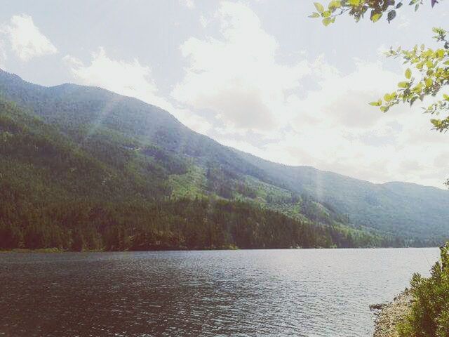 SCENIC VIEW OF RIVER AND MOUNTAINS AGAINST CLOUDY SKY