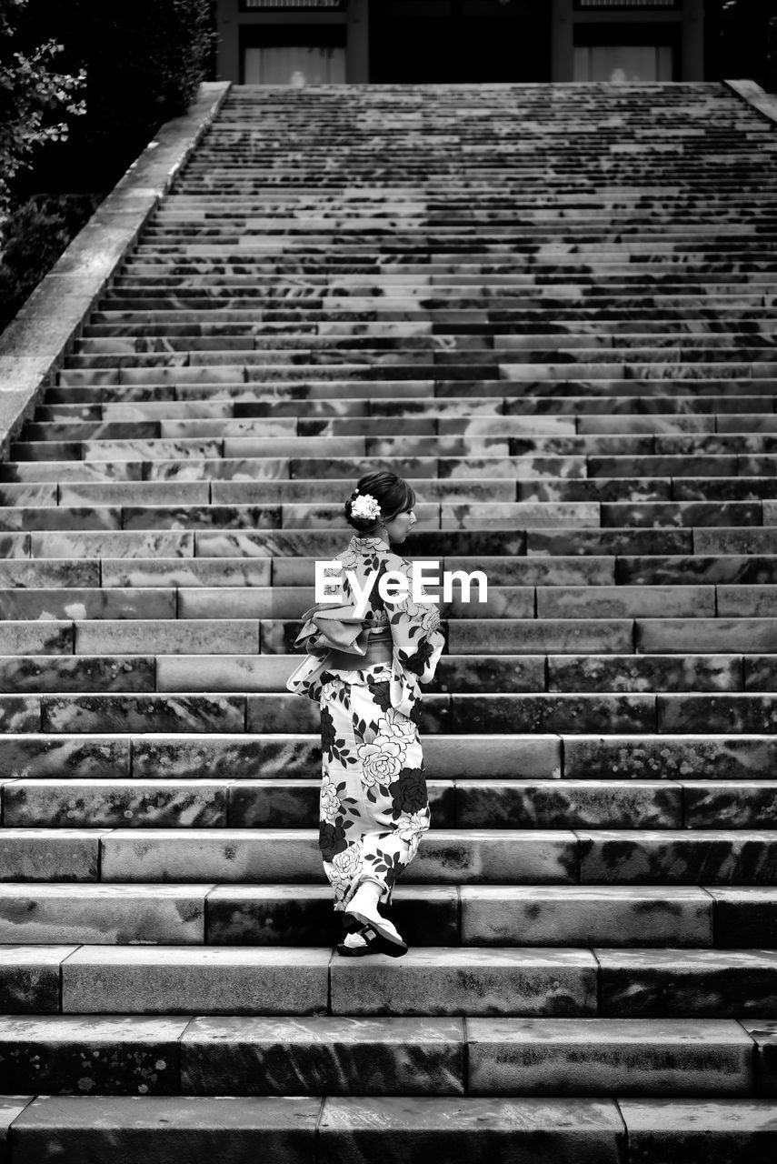 Rear view of woman walking on staircase