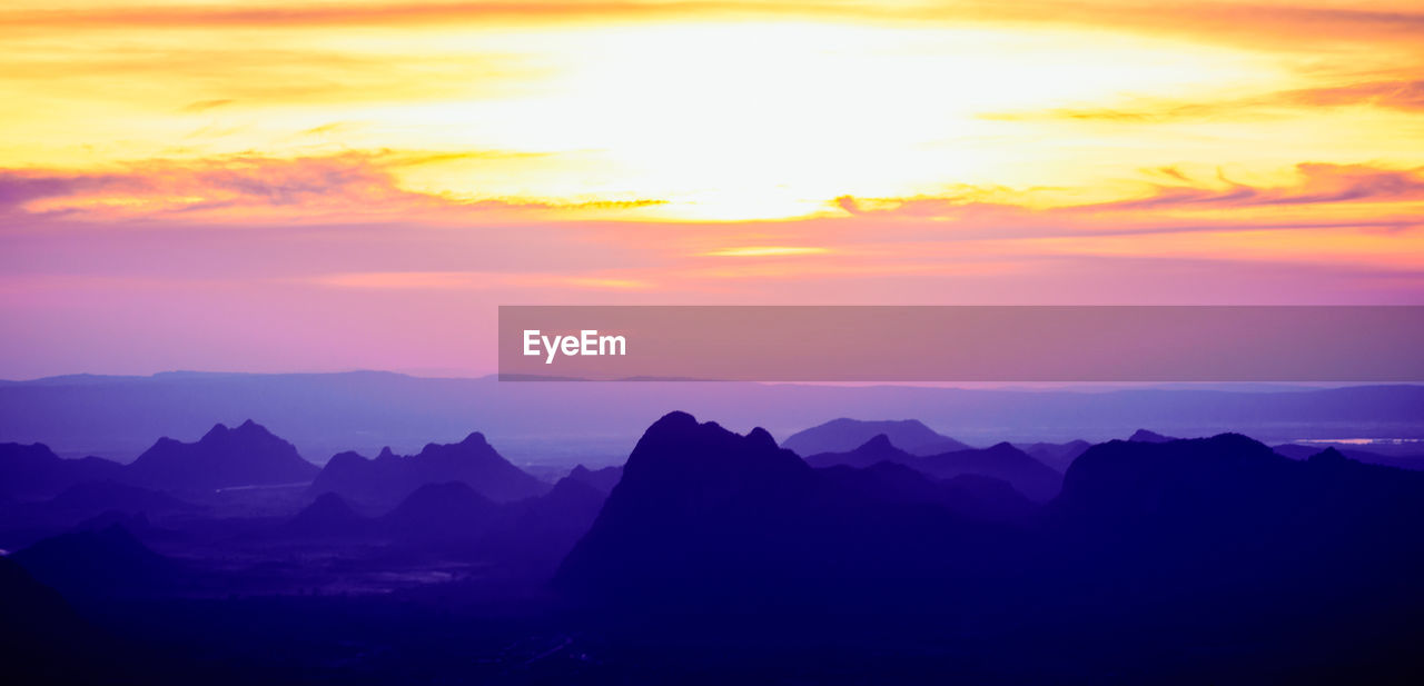 SCENIC VIEW OF MOUNTAINS AGAINST DRAMATIC SKY