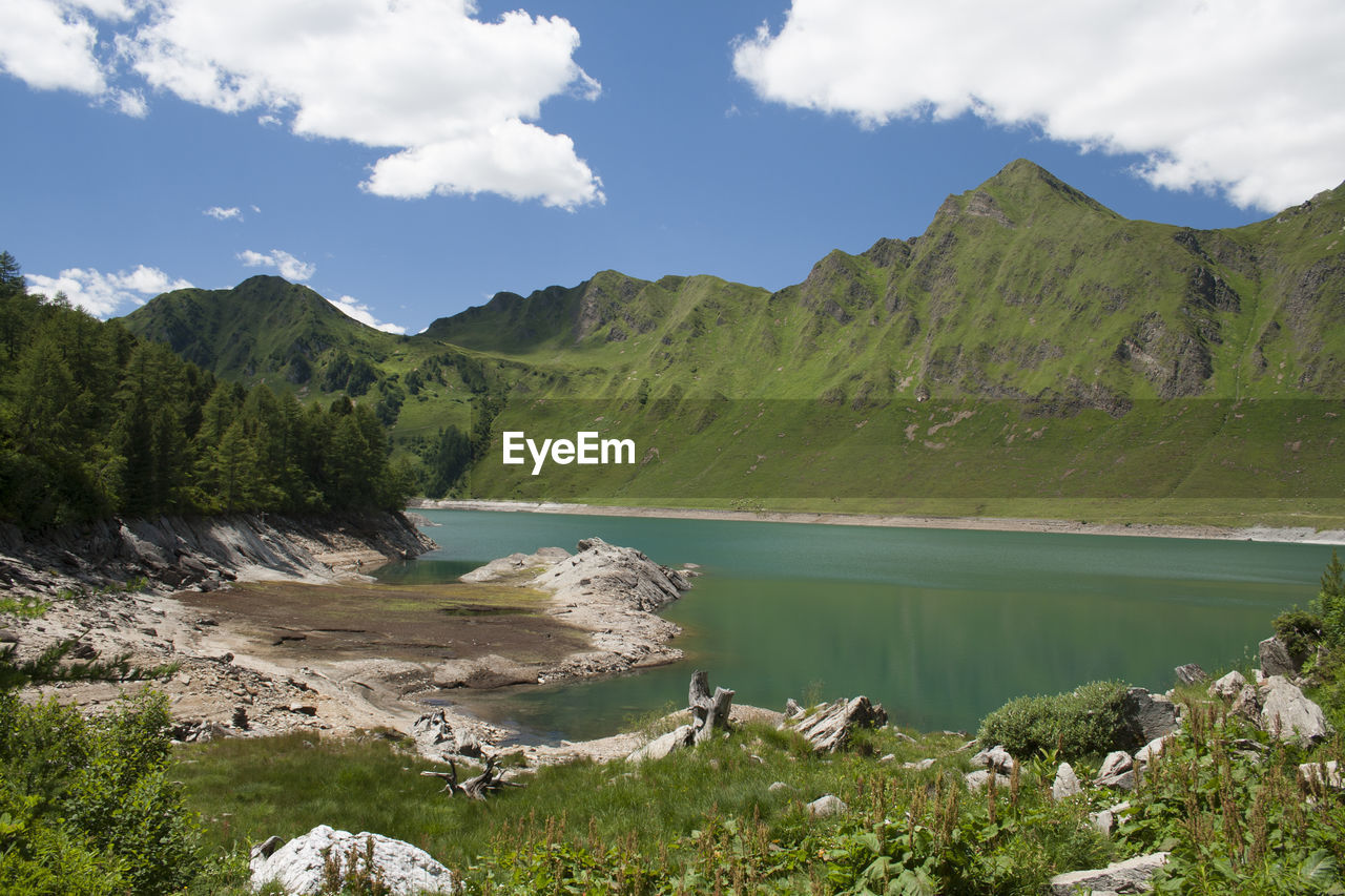 Scenic view of river and mountains against sky