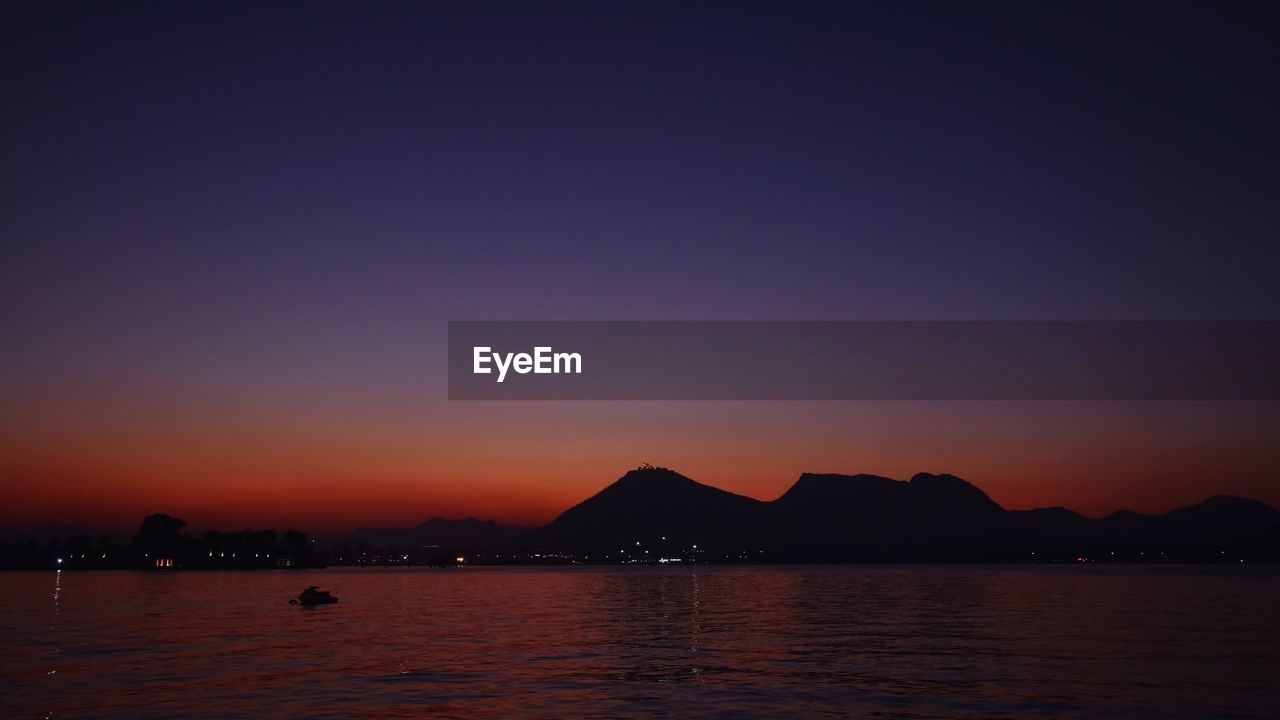 SCENIC VIEW OF SEA AGAINST SKY AT SUNSET