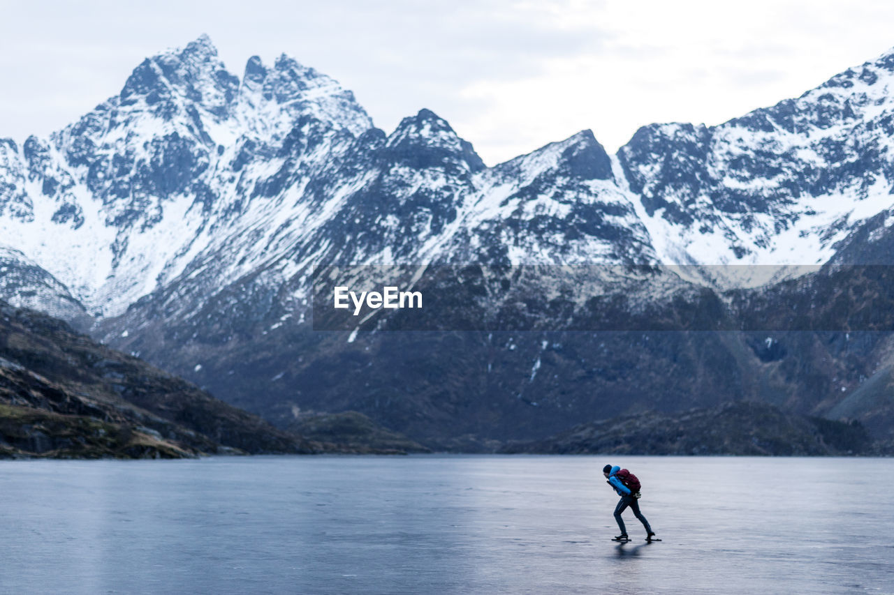 Man ice-skating on frozen lake