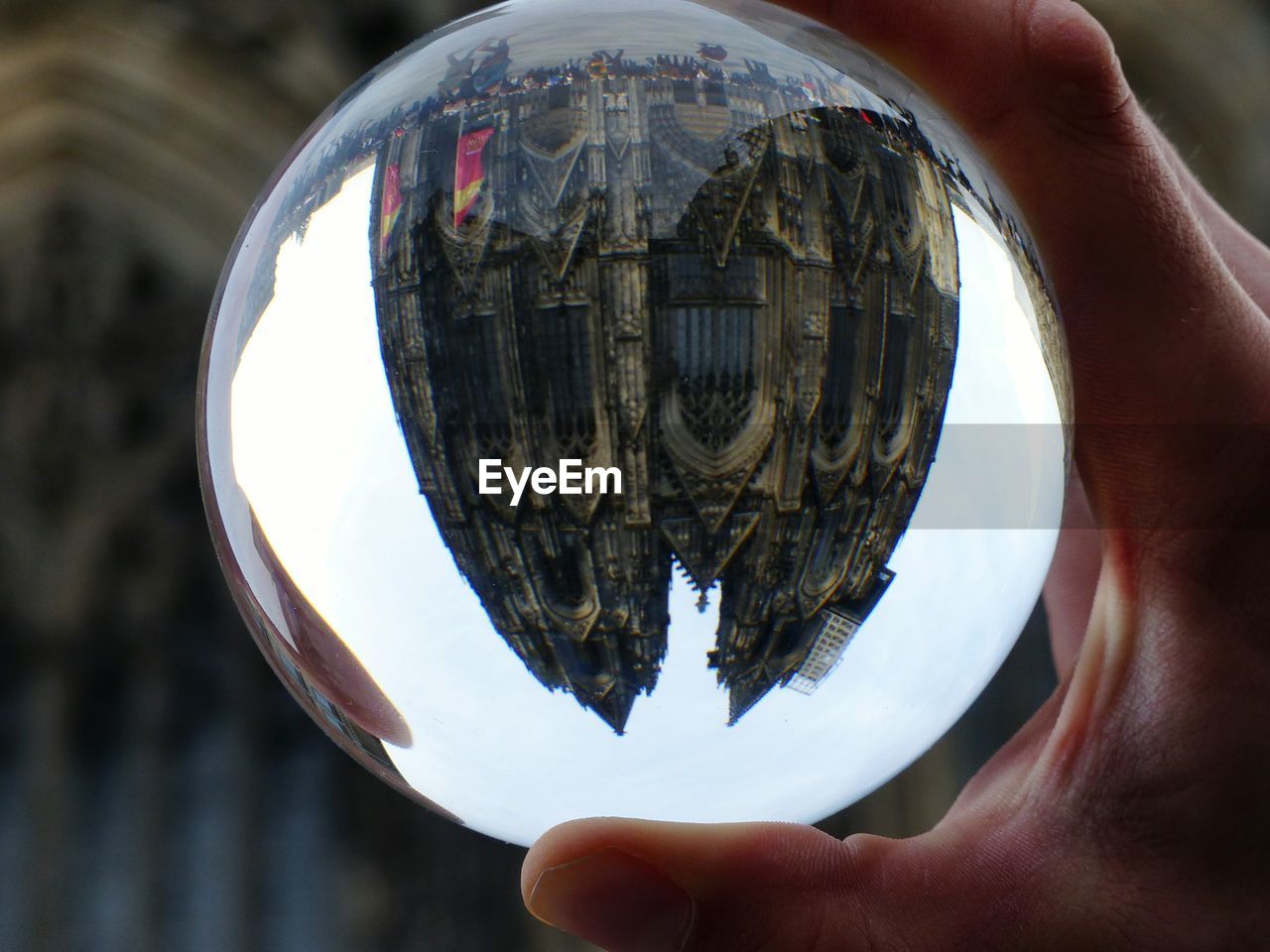 Cropped image of person holding crystal with upside down reflection