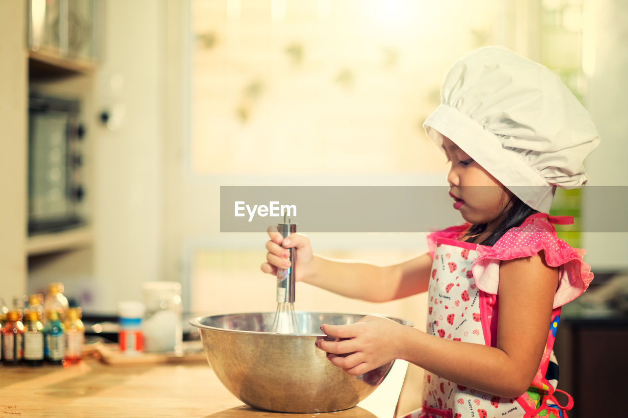 Girl preparing food in kitchen at home