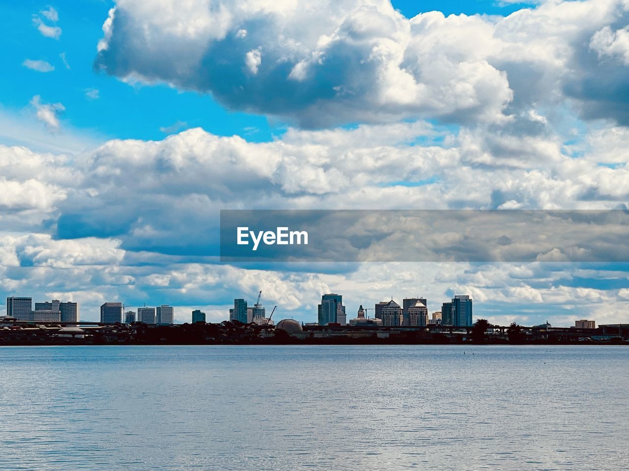 View of buildings in city against cloudy sky