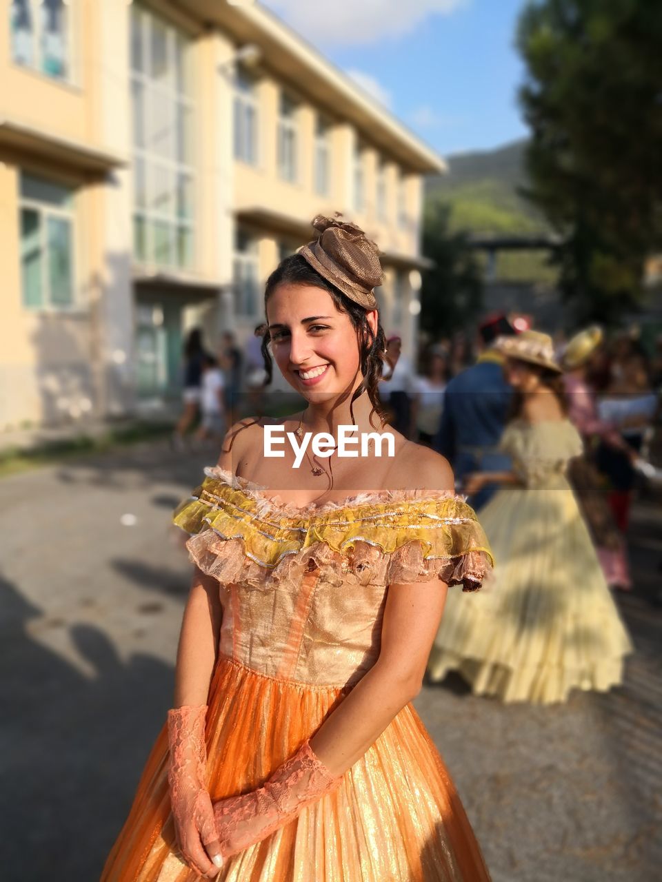 Portrait of fashionable smiling young woman standing outdoors