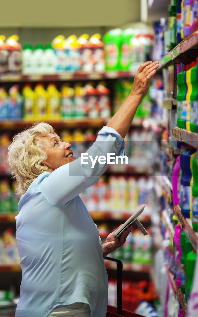 Side view of woman shopping at supermarket