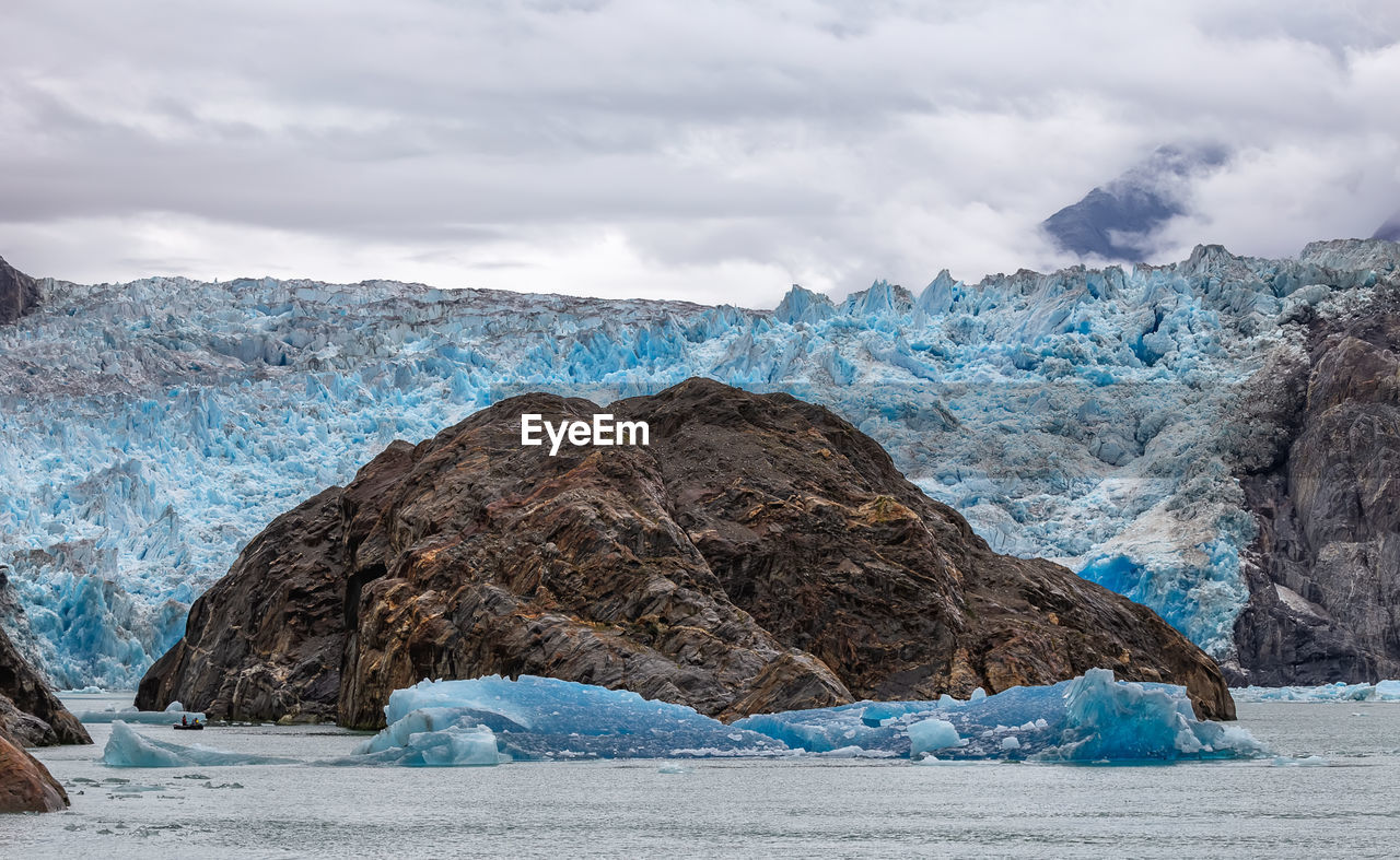 SCENIC VIEW OF GLACIER AGAINST MOUNTAIN