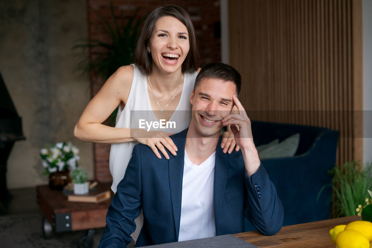 Laughing excited married couple rejoice in their happiness by winning prize