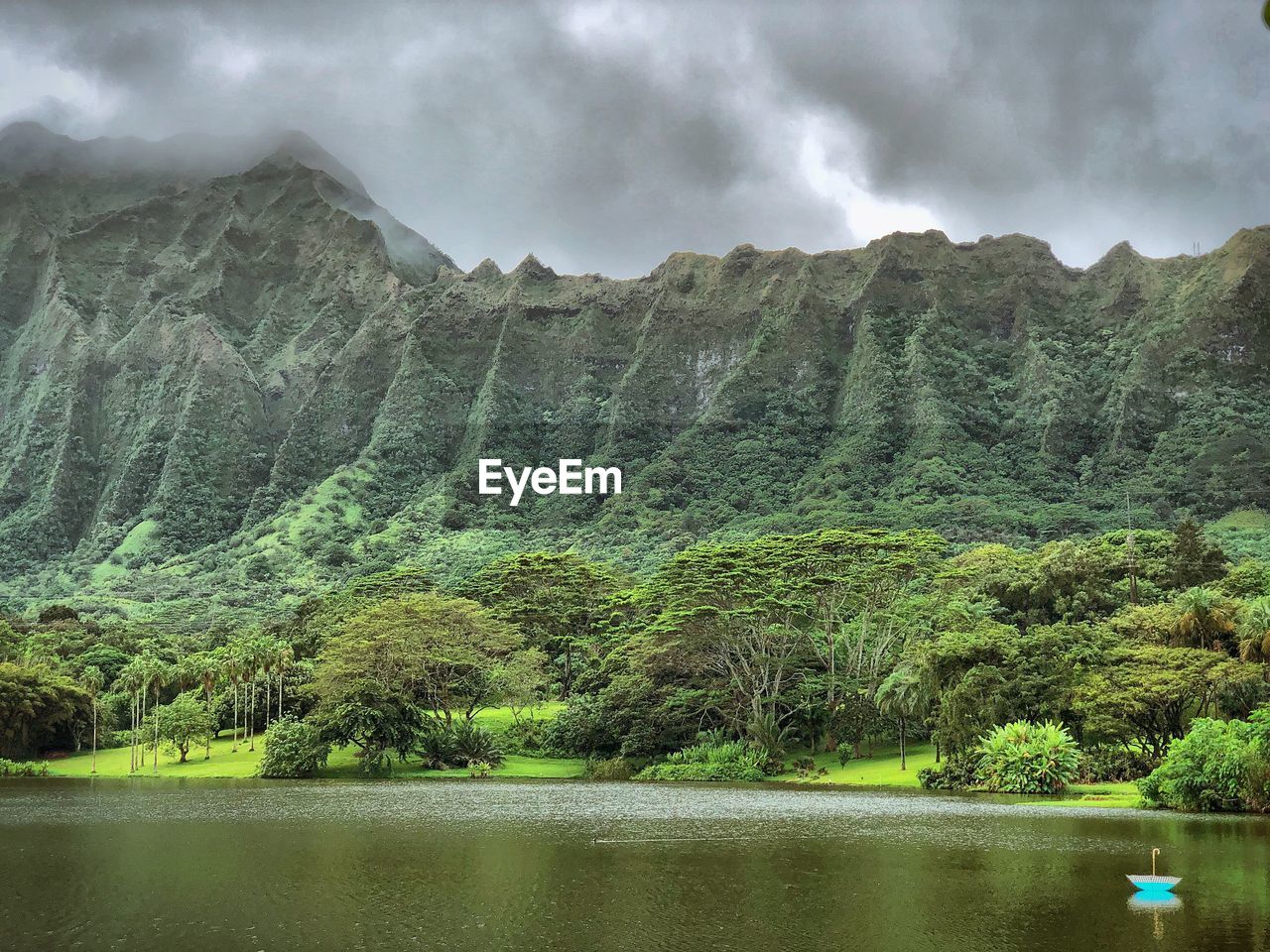 Scenic view of lake by mountains against sky