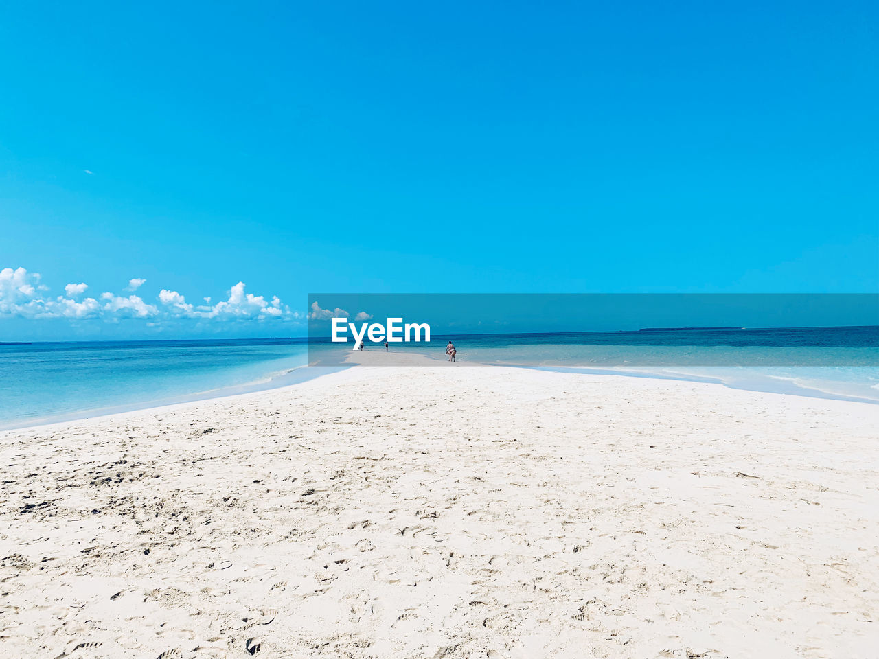 Scenic view of beach against blue sky