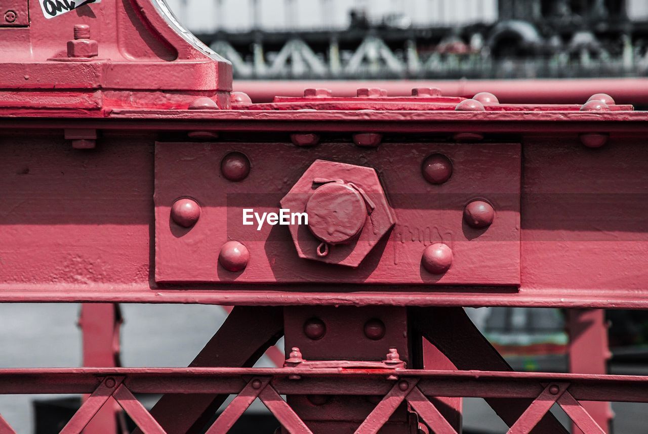 Close-up of red cropped of metallic bridge