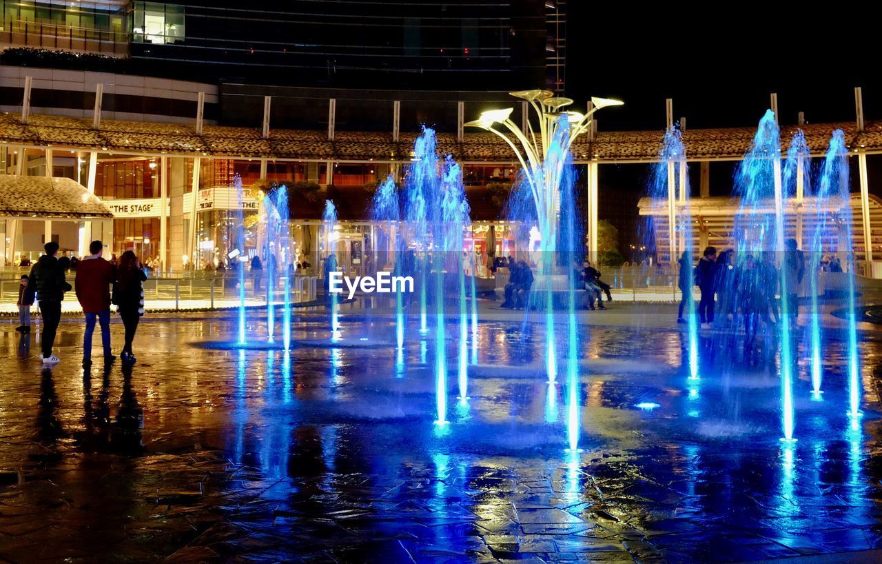 PEOPLE AT ILLUMINATED FOUNTAIN