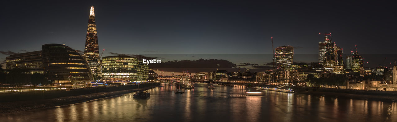 ILLUMINATED CITY BUILDINGS AT WATERFRONT