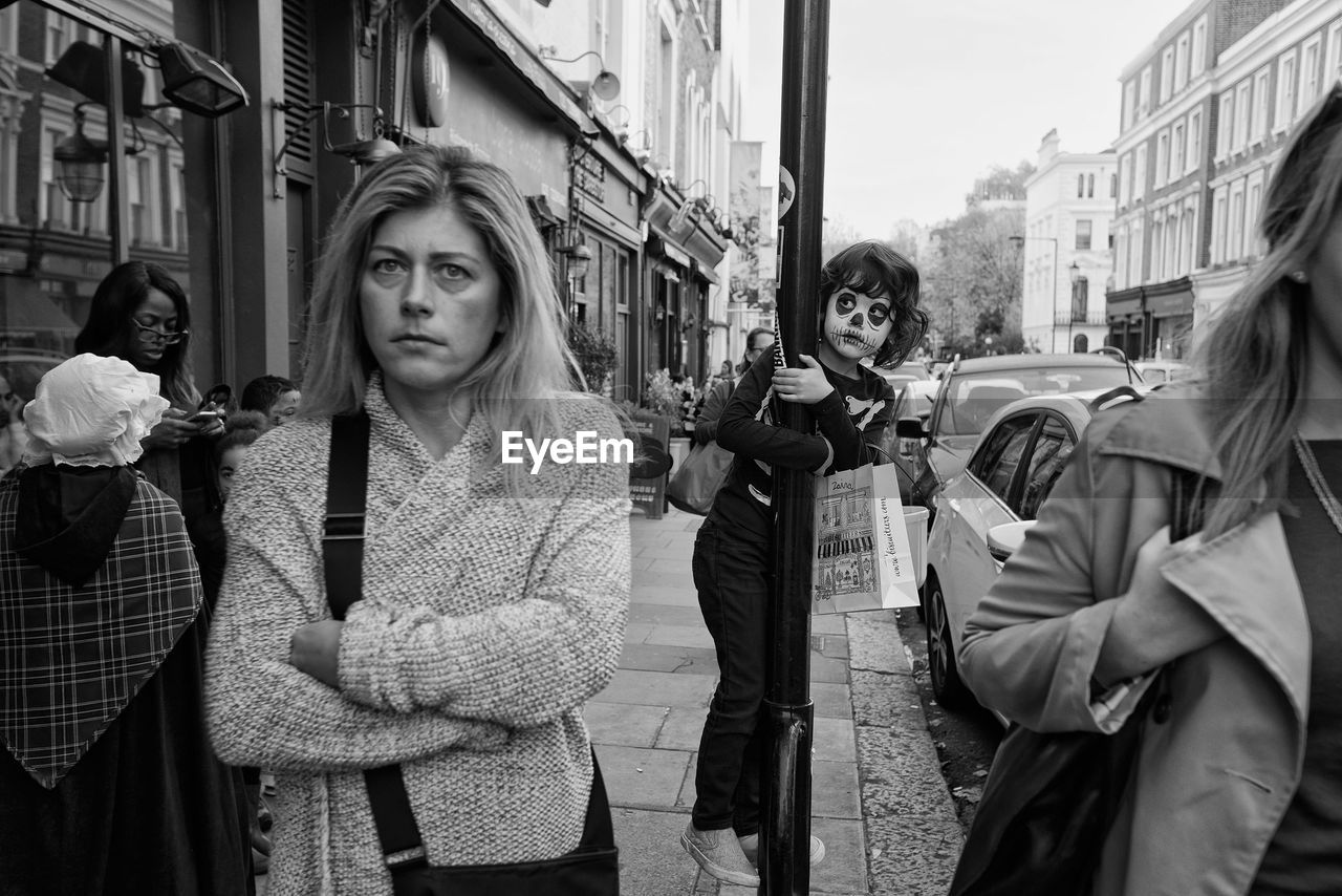 PORTRAIT OF TWO PEOPLE STANDING ON STREET IN CITY