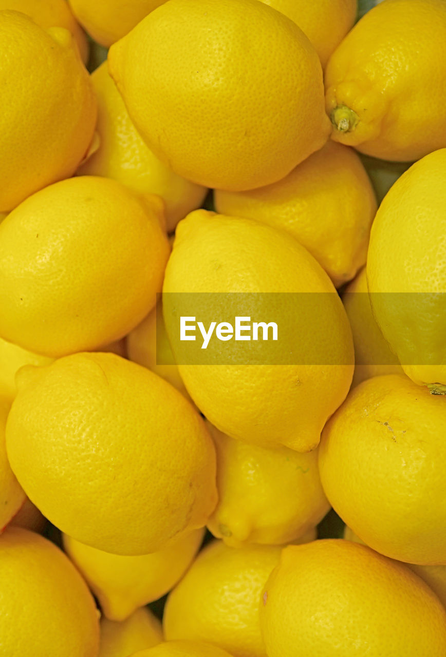 Pile of fresh ripe vibrant yellow lemons for backdrop or banner