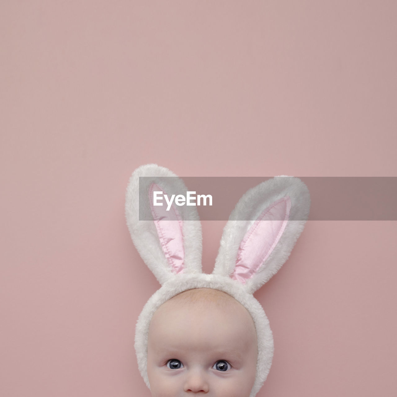 Portrait of cute baby against pink background