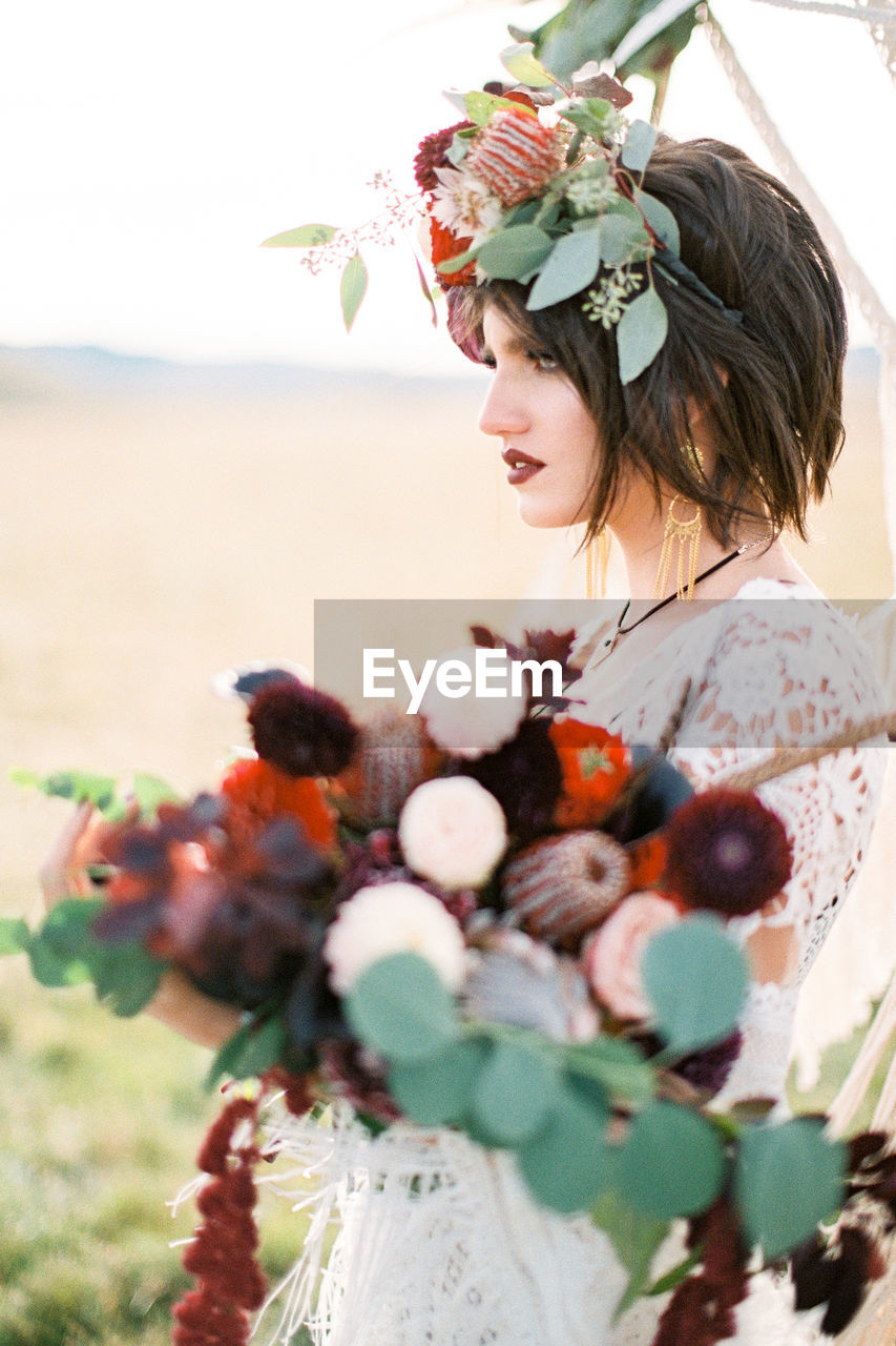 portrait of smiling young woman with bouquet