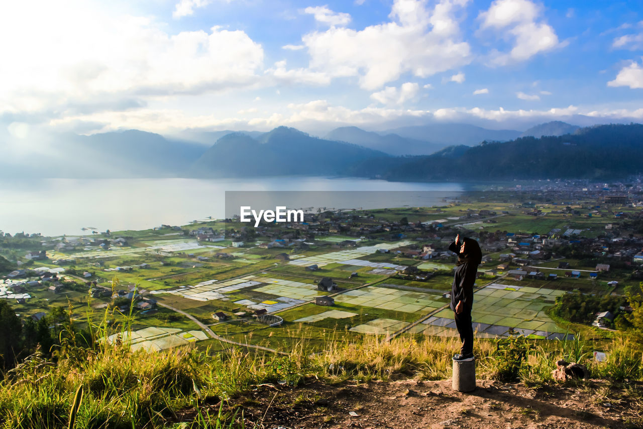 Girl standing on field against sky