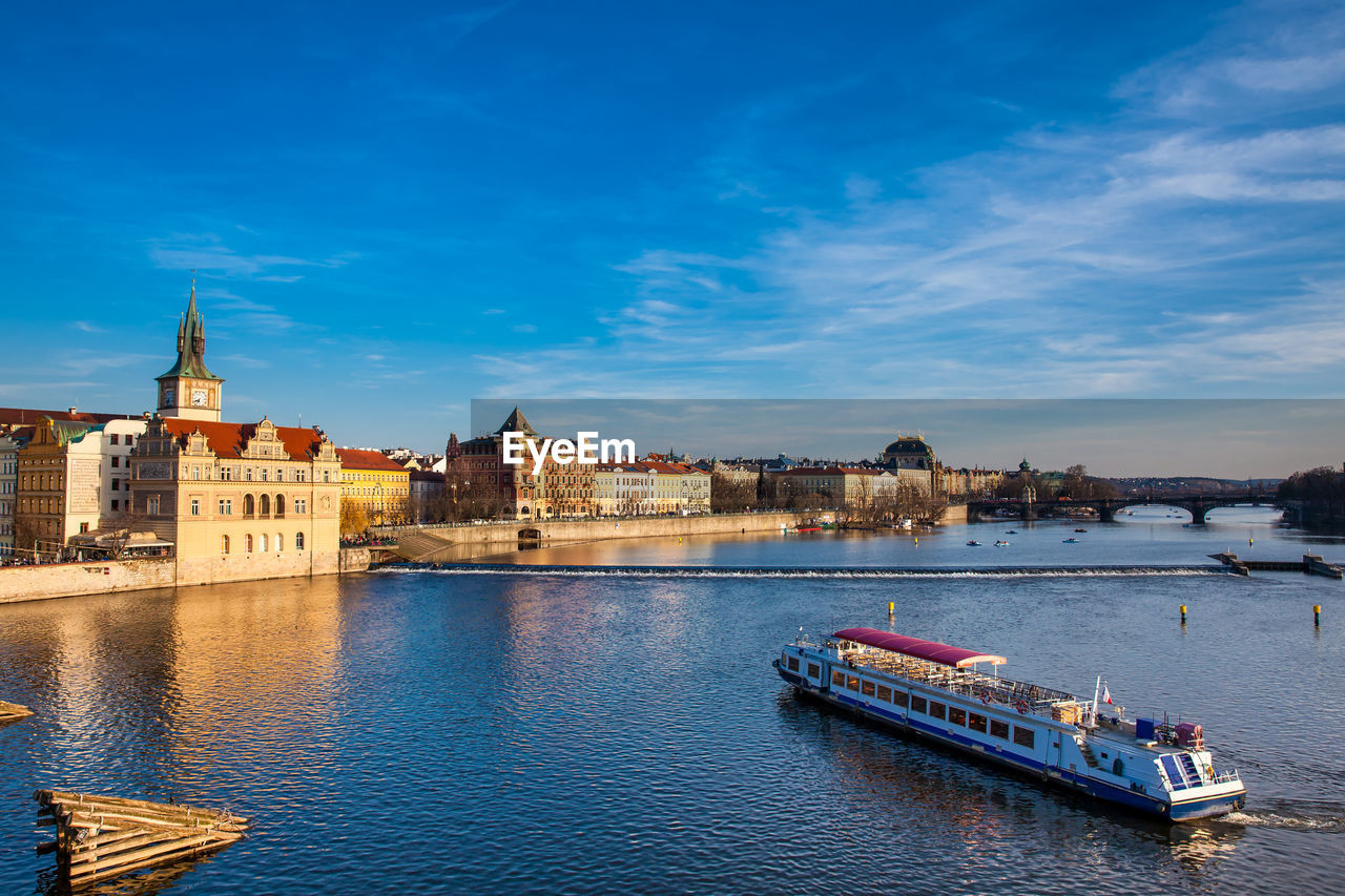 Boats in river with buildings in background